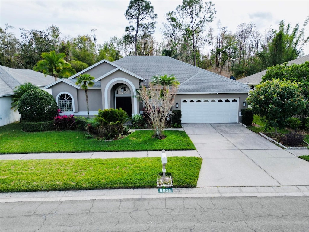 9625 Fox Hearst Rd, Tampa, FL 33647 - ranch-style home with a garage and a front yard