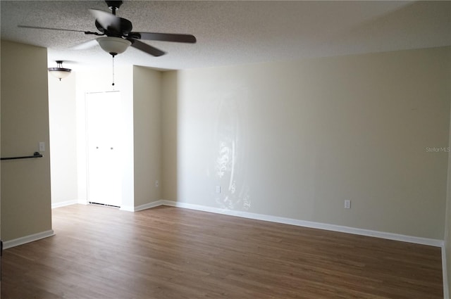 empty room with ceiling fan, hardwood / wood-style floors, and a textured ceiling