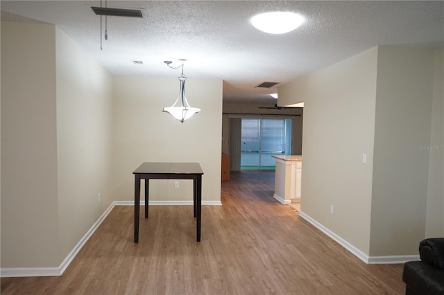 hallway with wood-type flooring and a textured ceiling