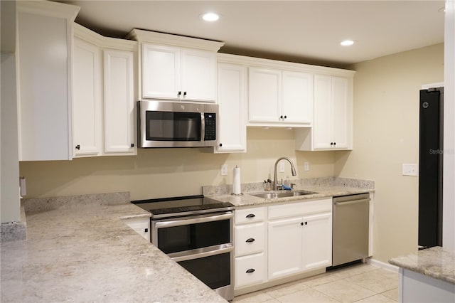 kitchen featuring light tile patterned flooring, appliances with stainless steel finishes, sink, and white cabinets