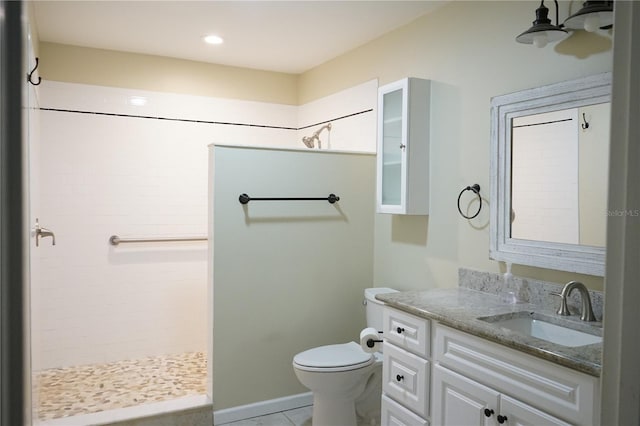 bathroom featuring tile patterned flooring, vanity, a shower, and toilet