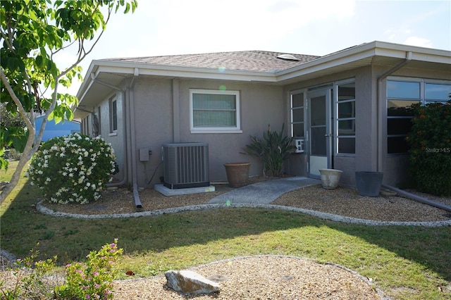 exterior space featuring a yard and central AC