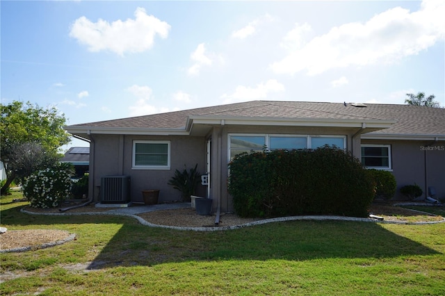 view of front facade featuring a front lawn and central air condition unit