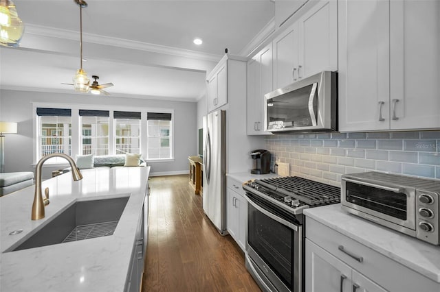 kitchen featuring white cabinetry, appliances with stainless steel finishes, light stone countertops, and backsplash