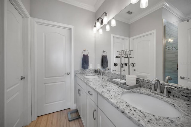 bathroom with wood-type flooring, vanity, crown molding, and walk in shower