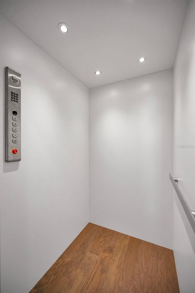 empty room featuring hardwood / wood-style flooring and elevator