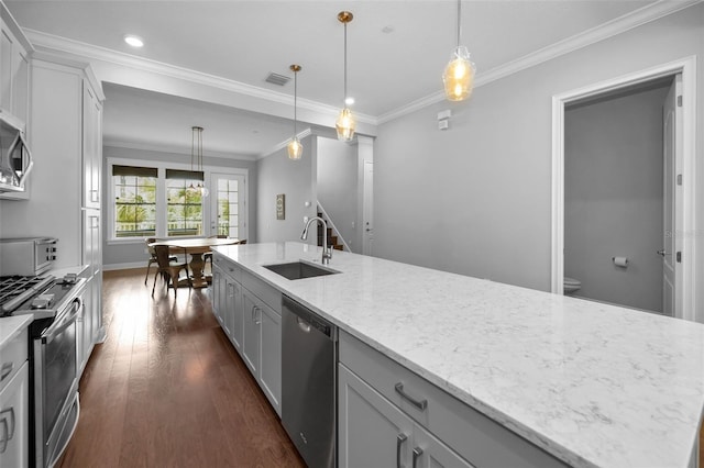 kitchen featuring sink, light stone counters, a center island with sink, appliances with stainless steel finishes, and pendant lighting