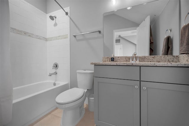 full bathroom featuring tile patterned flooring, vanity, tiled shower / bath, and toilet