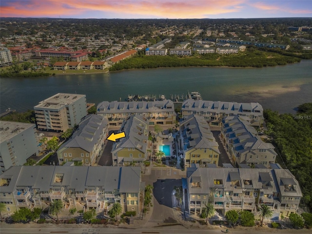 aerial view at dusk featuring a water view