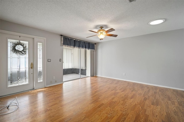 foyer featuring hardwood / wood-style flooring, plenty of natural light, and a textured ceiling