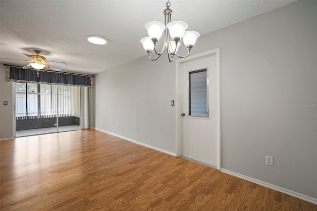 unfurnished room featuring ceiling fan with notable chandelier, wood-type flooring, and a textured ceiling