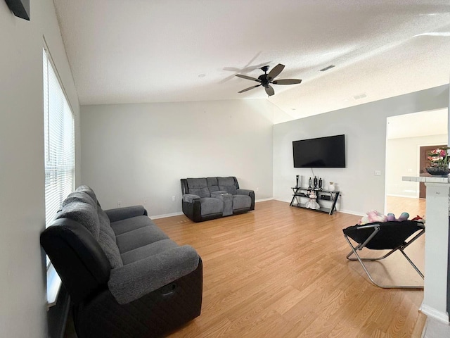 living room featuring vaulted ceiling, ceiling fan, and light hardwood / wood-style floors