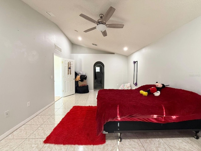 bedroom featuring ceiling fan, lofted ceiling, and light tile patterned floors