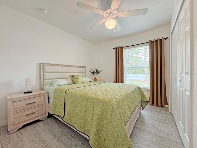 bedroom with a closet, ceiling fan, and light wood-type flooring