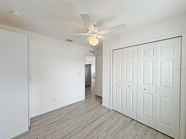 unfurnished bedroom with light hardwood / wood-style floors, ceiling fan, and a closet