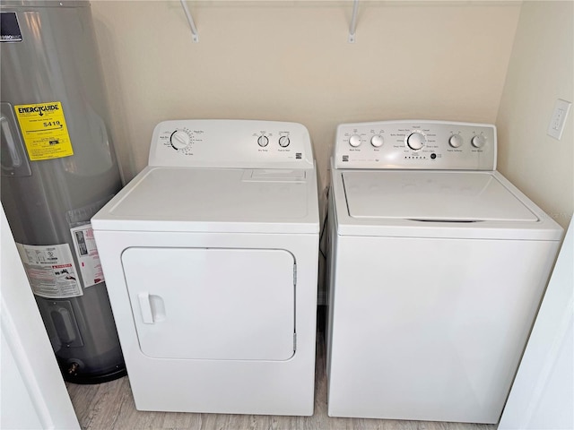 laundry room featuring separate washer and dryer, electric water heater, and light wood-type flooring