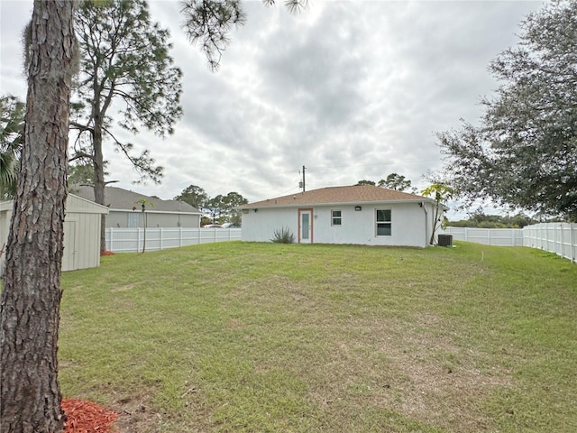 rear view of house with a yard and a shed