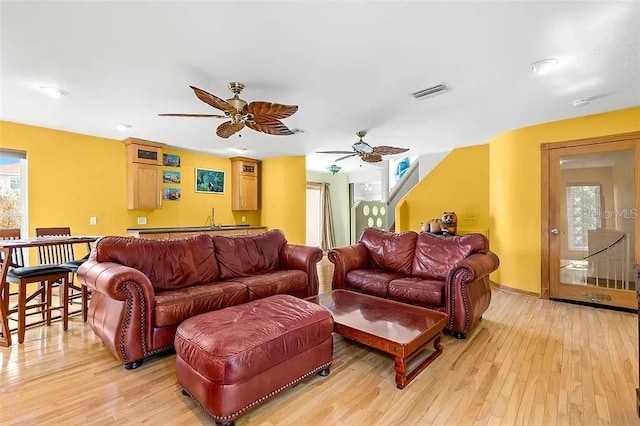 living room featuring light hardwood / wood-style floors and ceiling fan