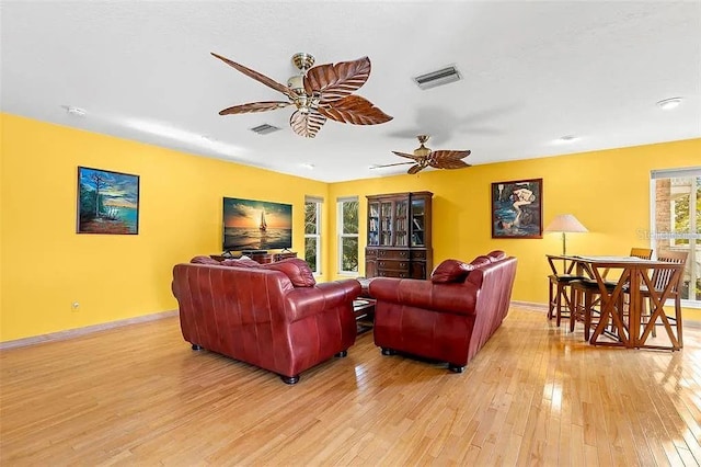 living room featuring ceiling fan and light hardwood / wood-style floors