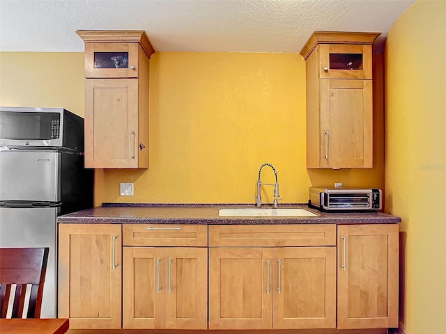 kitchen featuring appliances with stainless steel finishes, sink, and a textured ceiling