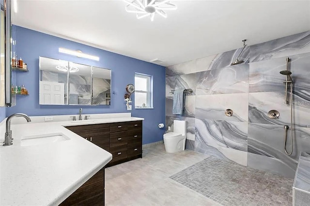 bathroom featuring vanity, toilet, and a tile shower