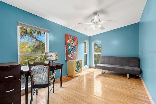 living area with ceiling fan and light hardwood / wood-style flooring