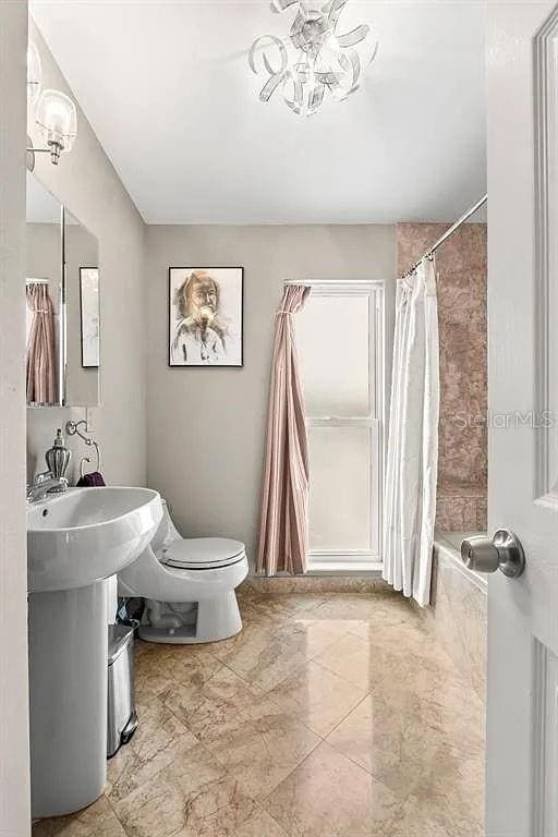 bathroom featuring toilet and shower / tub combo