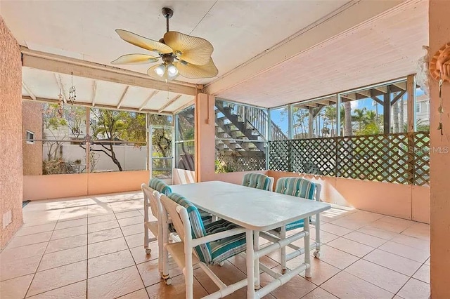 sunroom / solarium with ceiling fan and beamed ceiling