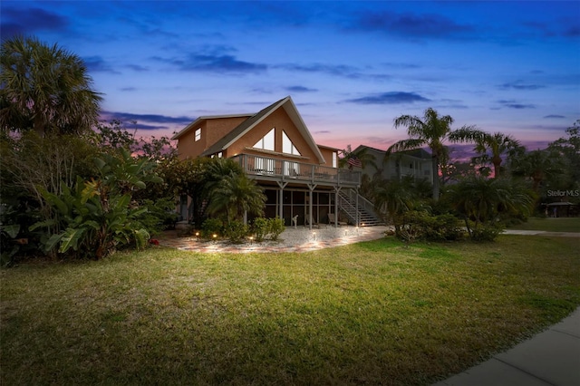 yard at dusk featuring a wooden deck