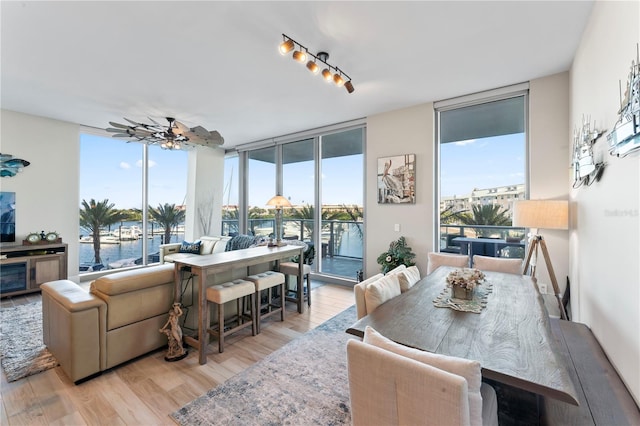 sunroom featuring a water view and ceiling fan