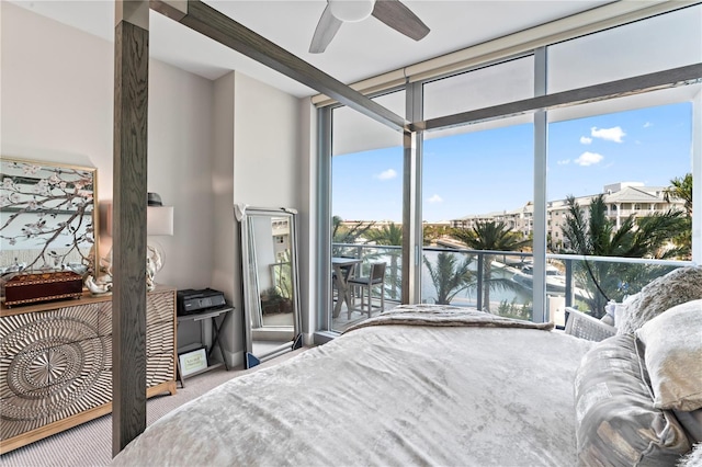 carpeted bedroom featuring floor to ceiling windows and a water view