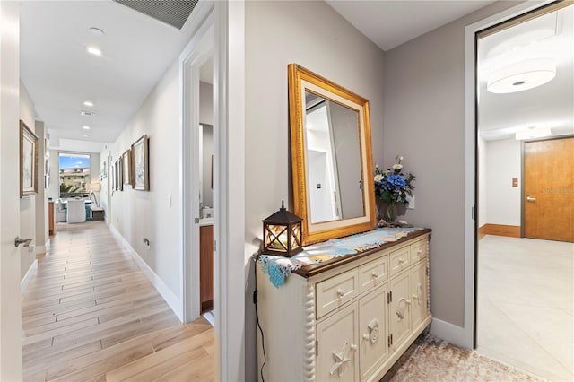 corridor with light hardwood / wood-style floors