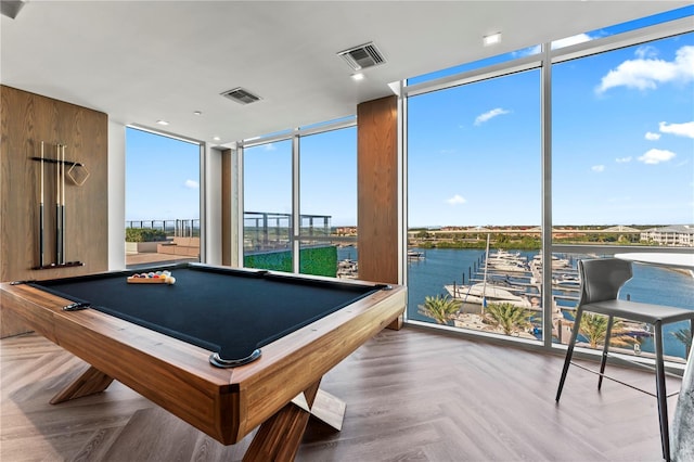 rec room with floor to ceiling windows, a water view, and parquet floors