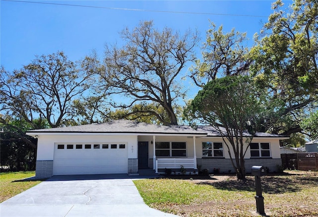 single story home with a front lawn, brick siding, driveway, and an attached garage