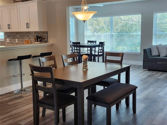 dining area with baseboards and wood finished floors