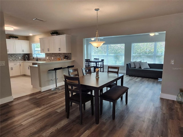 dining area featuring dark wood-style floors, baseboards, and visible vents