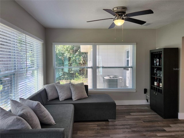 living area featuring visible vents, ceiling fan, a textured ceiling, wood finished floors, and baseboards