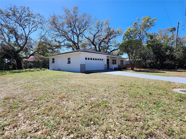 view of home's exterior featuring an attached garage, a yard, concrete driveway, and stucco siding