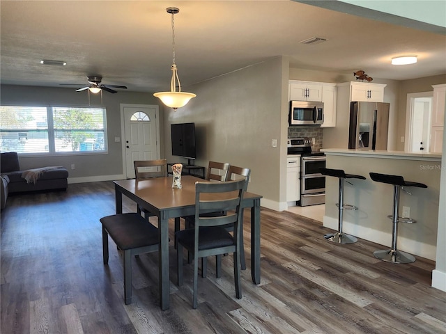 dining room featuring visible vents, dark wood finished floors, and baseboards