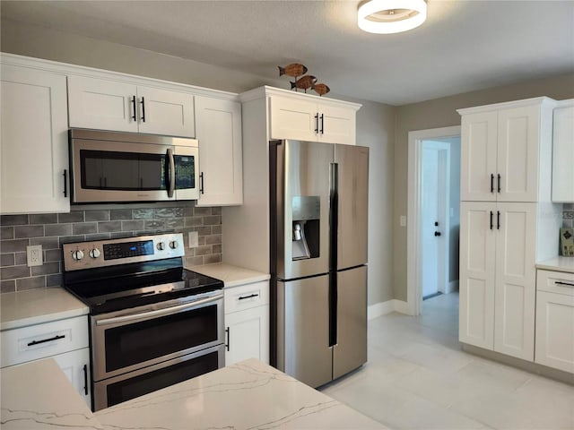 kitchen with stainless steel appliances, white cabinetry, and decorative backsplash