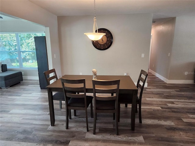 dining space featuring wood finished floors and baseboards