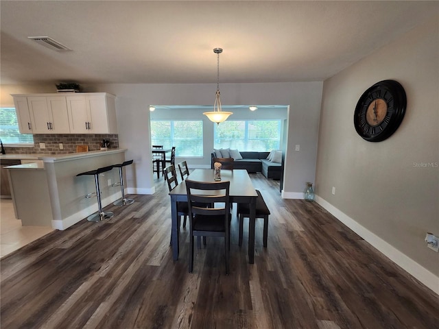 dining room featuring baseboards, visible vents, and dark wood-style flooring