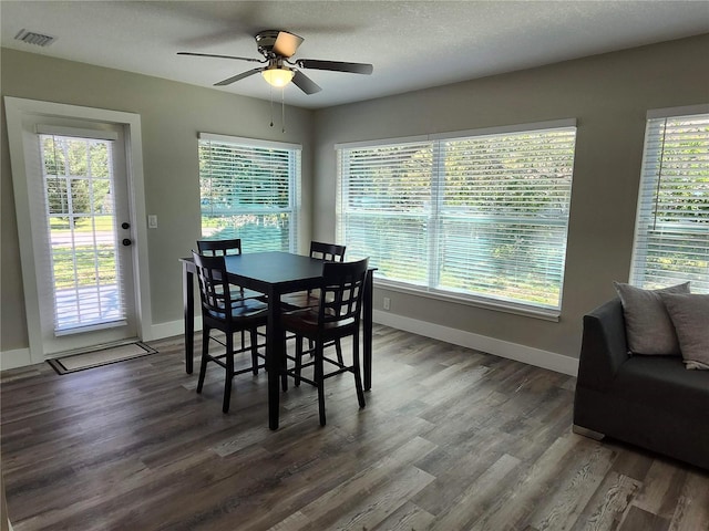 dining space featuring plenty of natural light, visible vents, and dark wood-style flooring