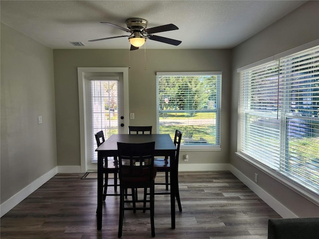 dining room with a textured ceiling, dark wood-style flooring, and baseboards