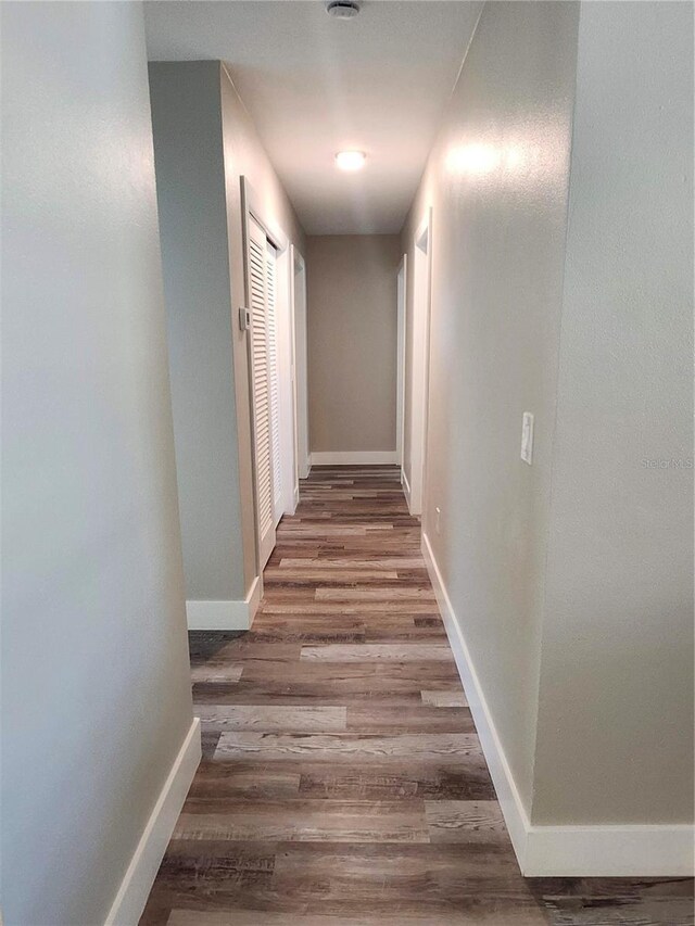 hall featuring baseboards and wood finished floors