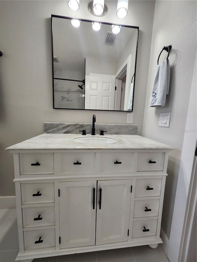 bathroom with a tub, visible vents, and vanity