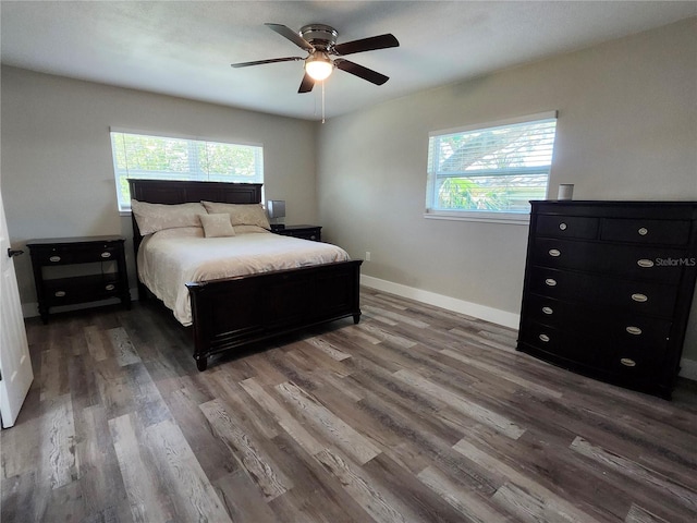 bedroom with ceiling fan, wood finished floors, and baseboards