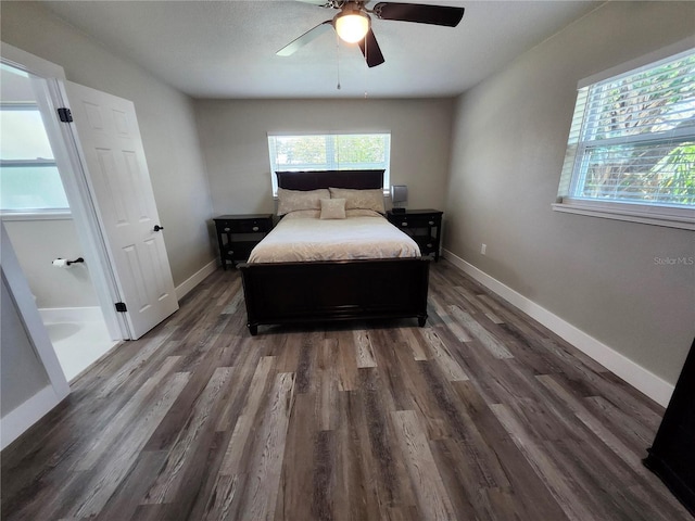 bedroom featuring a ceiling fan, multiple windows, baseboards, and wood finished floors