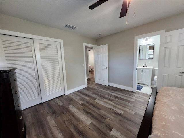 unfurnished bedroom featuring a closet, visible vents, baseboards, and wood finished floors