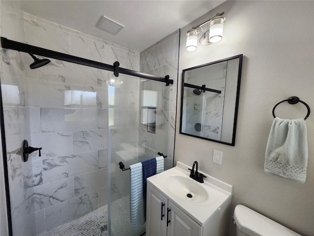 bathroom with visible vents, vanity, toilet, and a shower stall